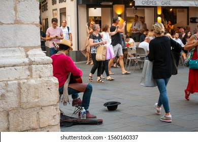 Nice, France - September 25 2019: A Young Male Street Musician Busking With A Guitar Plays For The Crowd In The Old Town Section Of Nice, France. 