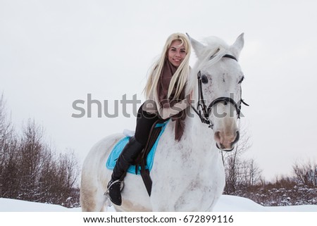 Nice girl and white horse outdoor in a winter day