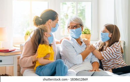 A Nice Girls, Her Mother And Grandmother Enjoying Spending Time Together At Home. People Wearing Face Masks.