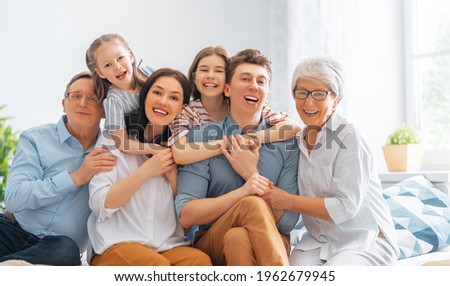 Nice girls, their mother, father, grandfather and grandmother are enjoying spending time together at home. Family time.