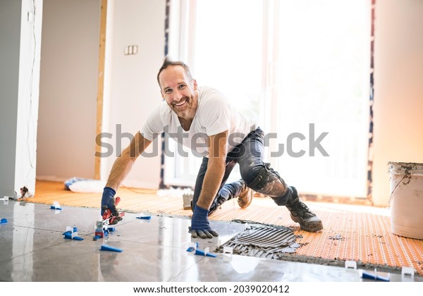 A nice handyman\
install tile on the floor