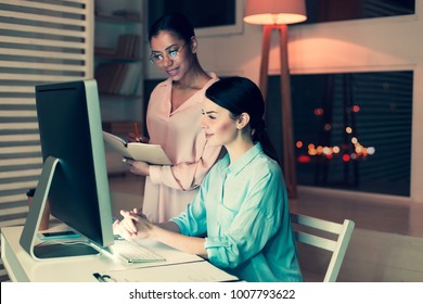 Nice Job. Pleasant Female Boss Standing Next To Her Colleague, Monitoring Her Research Progress By Reading An Interim Report And Taking Notes About It