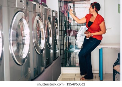 Nice lady with red shirt enjoy technology using smartphone while automatic laundry wash and dry her clothes - modern lifestyle ofr urban girl - Powered by Shutterstock