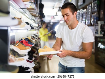 Nice Male Customer Choosing Sneakers In Streetwear Store