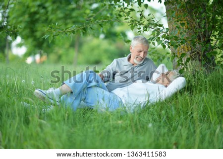 Nice mature couple sitting on green grass