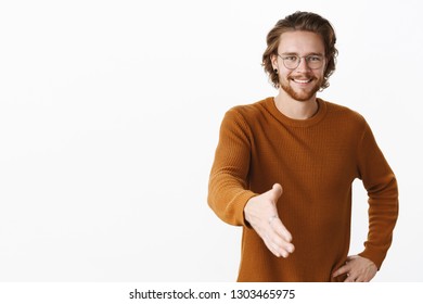 Nice to meet you. Portrait of friendly good-looking young boyfriend meeting parents of girlfriend pulling hand towards camera in handshake gesture smiling wanting make good impression