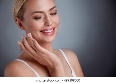 Nice Middle Aged Woman  Applying Face Cream, Joyfully Smiling