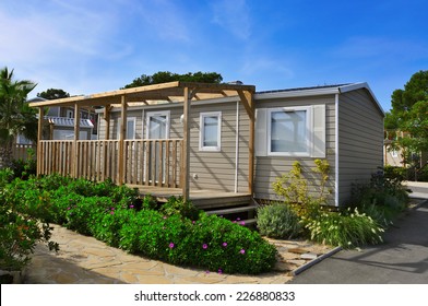 a nice mobile home with a wooden veranda in a campsite