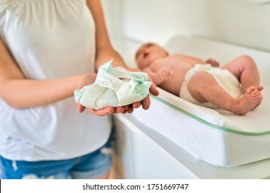 A nice mother Changing Baby's Diaper In nursery