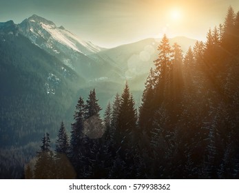 Nice mountains view at sunny day with skiers under blue sky with sun light at winter time.