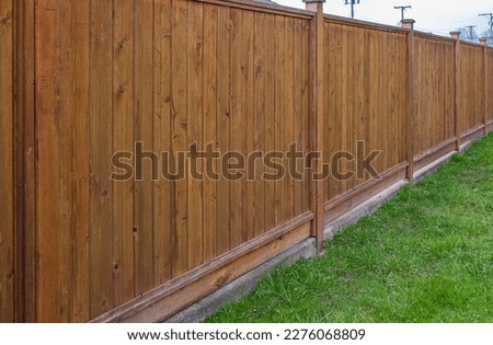 Nice new white wooden fence around house. Wooden fence with green lawn. Street photo, nobody, selective focus