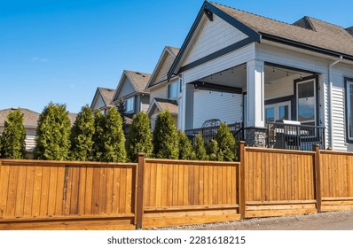 Nice new wooden fence around house. Wooden fence. Street photo, nobody, selective focus. Real Estate Exterior Front House on a sunny day - Shutterstock ID 2281618215