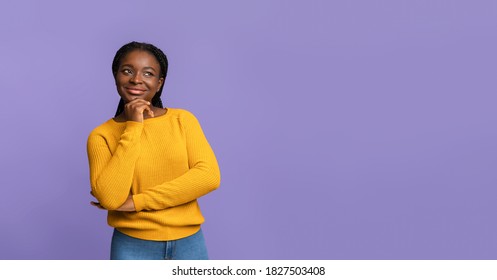 Nice Offer. Curious African American Woman Looking Away At Copy Space On Purple Background, Thoughtful Black Female Touching Chin, Thinking About Something And Playfully Smiling, Panorama