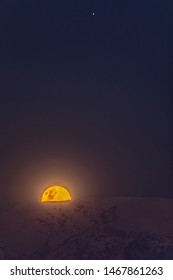 A nice planetary conjunction over the night sky. Jupiter, top right, and the Moon, low left, rising above the snowy Andes mountains range during a winter day. An awe Moon bright landscape