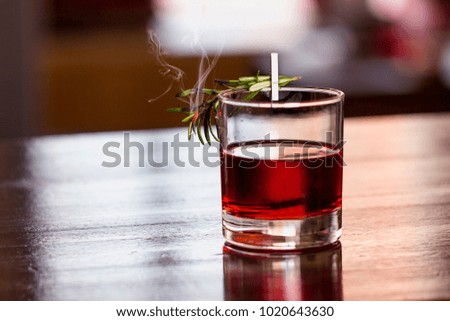 Nice red cocktail with a branch of rosemary