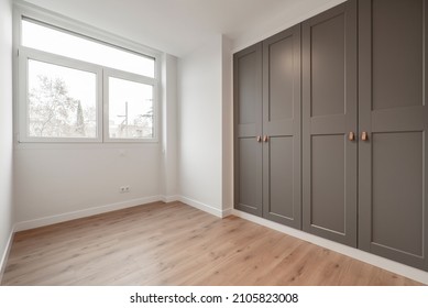 Nice room with large window, pine wood floors and built-in wardrobes with gray doors