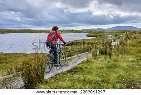 nice senior woman on mountain bike, cycling bog Area near Derrycunlagh, County Galway, in  the western part of the Republic of Ireland