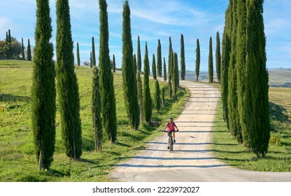 nice senior woman riding her electric mountain bike in the awesome landscape of Tuscany,Italy