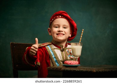 Nice sign. Little charming kid in historical costume smiling and thumb up over dark green background. Concept of fast food, comparison of eras, retro, vintage, emotions. Looks happy - Powered by Shutterstock