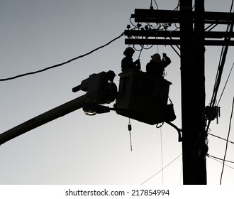 Nice Silhouette Image Of Men Replacing A Power Line