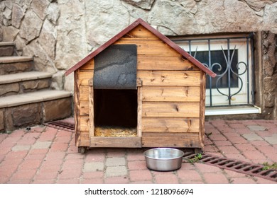 Nice Solid Wooden Doghouse Without A Dog Settled Close To The House, With An Empty Bowl, Outdoors, Summer Time. Outdoors, Copy Space.