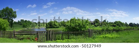 nice summer panorama of village landscape with fence and river