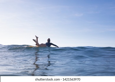 Nice surf girl paddling on a longboard