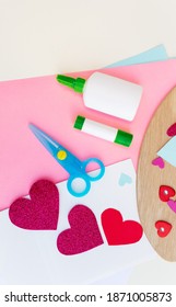 Nice Valentines Day Card With Paper Hearts, Scissors, Glue Stick, Colored Paper Sheets On A Wooden Background. Creative Valentines Day Card Crafts. Easy Paper Craft Projects. Top View