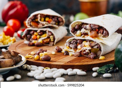 Nice Vegetarian Burrito Over Black Table On Wooden Board