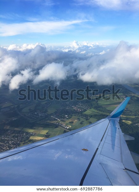 Nice view in between the clouds on a flight to\
Düsseldorf, Germany. Beautiful blue sky beyond the could and dark\
weather on the ground.