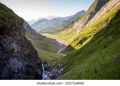 Nice view of a valley surrounded by mountains with a waterfall and a river