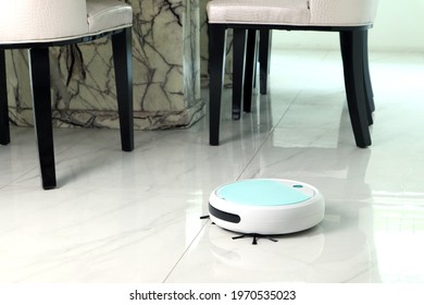 Nice White Modern Automatic Scan Robotic Vacuum Is Cleaning The Dining Room Of The House After New Year Party Lunch