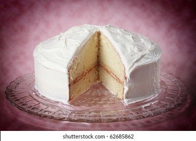 nice white vanilla cake with a missing piece on a glass plate