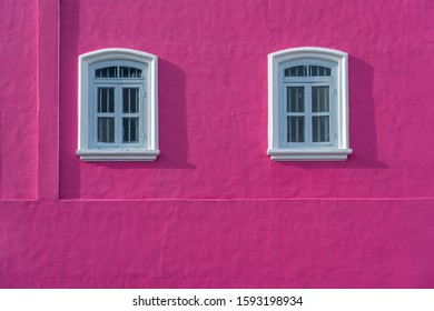 Nice white windows on pink concrete wall with shadow - Shutterstock ID 1593198934