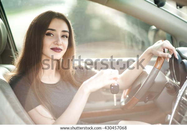 Nice woman, auto business, car sale, gesture and
people concept - happy businesswoman or saleswoman with folder
giving car key over inside the
car