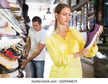 Nice Woman Choosing Sneakers In Streetwear Store