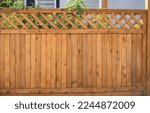 Nice wooden fence around house. Wooden fence with green lawn. Street photo, nobody, selective focus