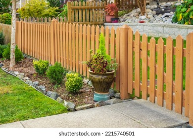 Nice wooden fence around house. Wooden fence with green lawn. Entrance gate. Street photo, nobody, selective focus