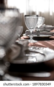 Nicely served table in the restaurant. Table setting with glasses, wine glasses, cutlery, plates and napkins.
