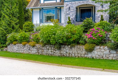 Nicely Trimmed Bushes, Flowers And Stones In Front Of The House, Front Yard. Landscape Design.