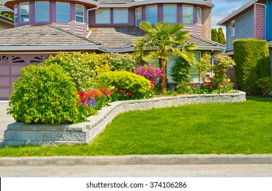 Nicely Trimmed Bushes, Flowers And Stones In Front Of The House, Front Yard. Landscape Design.