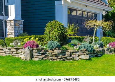 Nicely Trimmed Bushes, Flowers And Stones In Front Of The House, Front Yard. Landscape Design.