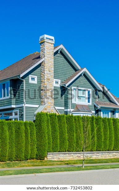 Nicely trimmed bushes  in front of the house.\
Landscape design.