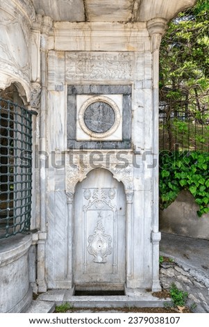 Niche at the white marble walls of Haci Mehmet Emin Aga Fountain, or Sebil, near Dolmabahce palace, Istanbul, Turkey. Text above translates: In the name of God, the most gracious, the most merciful