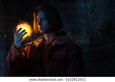 Nicholas Copernicus author of the heliocentric system of the world, the scientific revolution. History of scientific progress. A young man in the image of a scientist, holding the sun in his hand