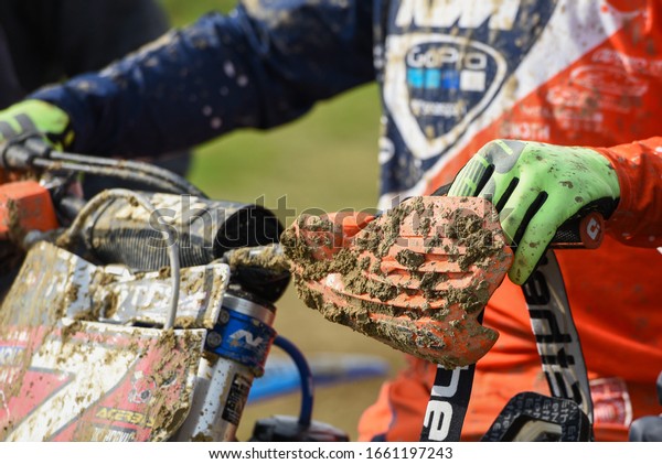 Nicosia, Cyprus,\
January 13 2019: Athlete on a motorbike and covered with mud during\
a motocross athletic\
event