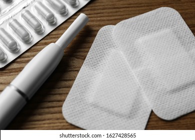 Nicotine Patches, Pills And Electronic Cigarette On Wooden Table, Closeup