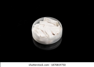 Nicotine Pouch Container Isolated On A Black Background With Reflection. Outer Space. Studio Shot. Snus Tobacco Product.