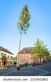 Nideggen, Germany - May 2022: Maypole on the square of a german town. The festival announces the beginning of summer with associated growth and blossoming of nature. The maypole symbolizes fertility.