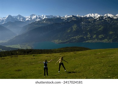 Niederhorn, Emmental Alps, Bernese Oberland, canton Bern, Switzerland, Europe : two young female tourists, panoramic view from the top on Thun Lake and Jungfrau-Aletsch mountains area, UNESCO - Powered by Shutterstock